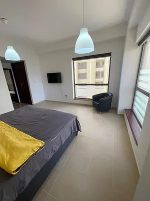 a bedroom with a bed and a chair and a window at Two Bedroom Apartment with Excellent Location in Dubai