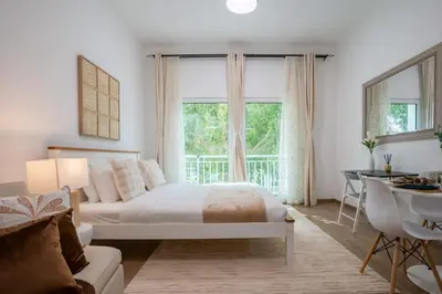 a bedroom with a bed and a desk and a window at Airstay - Upgraded Studio - Near Pool & Metro - Monthly Offer Available! in Dubai