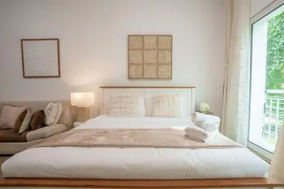a white bedroom with a large bed and a couch at Airstay - Upgraded Studio - Near Pool & Metro - Monthly Offer Available! in Dubai
