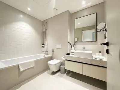 a bathroom with a tub and a toilet and a sink at Sea View Apartment at Emaar Beachfront by KeyRock in Dubai