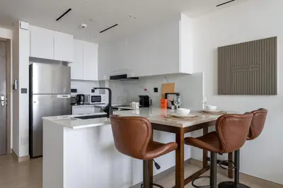 a kitchen with a table and chairs in a kitchen at GuestReady- Comfortable 1 bedroom- High Floor in Dubai