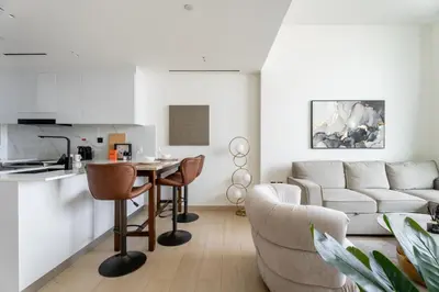 a living room with a couch and a table and chairs at GuestReady- Comfortable 1 bedroom- High Floor in Dubai
