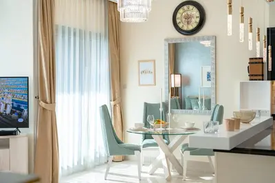 a dining room with a table and chairs and a mirror at Damac Maison Mall Street LARGE 2BR I Full Burj Views I Connects Dubai Mall in Dubai