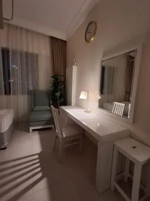 a room with a desk with a mirror and a chair at Damac Maison Mall Street LARGE 2BR I Full Burj Views I Connects Dubai Mall in Dubai