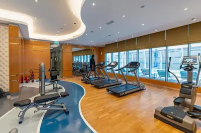 a gym with treadmills and ellipticals in a building at Damac Maison Mall Street LARGE 2BR I Full Burj Views I Connects Dubai Mall in Dubai