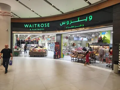 a store in a shopping mall with people walking through it at Damac Maison Mall Street LARGE 2BR I Full Burj Views I Connects Dubai Mall in Dubai