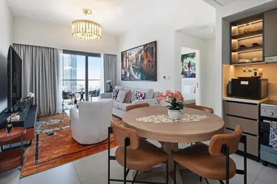 a kitchen and living room with a table and chairs at Stylish 1BR, Walk to Burj Khalifa and Dubai Mall in Dubai