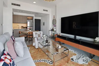 a living room with a large flat screen tv at Stylish 1BR, Walk to Burj Khalifa and Dubai Mall in Dubai