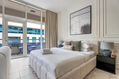 a bedroom with a large bed and a balcony at GuestReady | Studio | Partial Burj Khalifa View in Dubai
