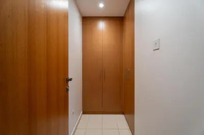 a hallway with a wooden door and a tile floor at GuestReady | Studio | Partial Burj Khalifa View in Dubai