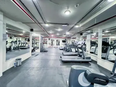 a gym with treadmills and machines in a room at GuestReady | Studio | Partial Burj Khalifa View in Dubai