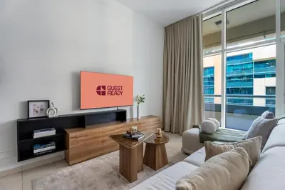 a living room with a couch and a tv at GuestReady | Studio | Partial Burj Khalifa View in Dubai