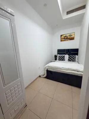 a bedroom with a bed in a white room at Bienvenue Homes in Dubai