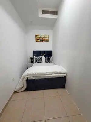 a bedroom with a bed in a white wall at Bienvenue Homes in Dubai
