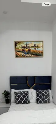 a painting above a bed in a bedroom at Bienvenue Homes in Dubai