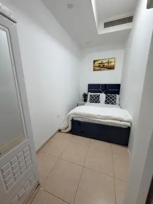 a bedroom with a bed in the corner of a room at Bienvenue Homes in Dubai