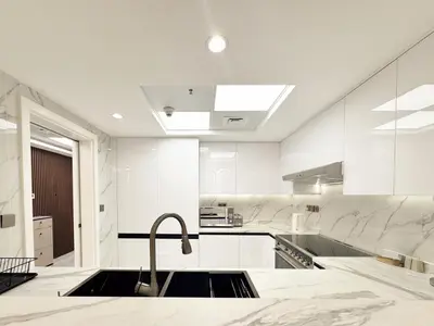 a white kitchen with a sink and a faucet at Dream Shoma-2BR - Pool - Walk to Burj Khalifa in Dubai