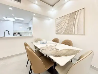 a dining room with a large marble table and chairs at Dream Shoma-2BR - Pool - Walk to Burj Khalifa in Dubai