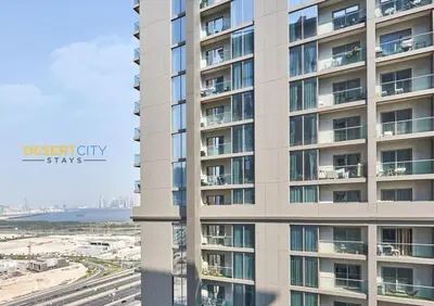 an apartment building with the ocean in the background at Stylish and Sophisticated Home Near Downtown Dubai Hosted by Desert City Stays in Dubai
