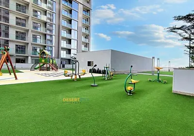 a playground with swings and play equipment on the grass at Stylish and Sophisticated Home Near Downtown Dubai Hosted by Desert City Stays in Dubai