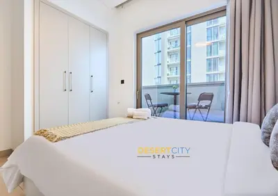 a bedroom with a white bed and a large window at Stylish and Sophisticated Home Near Downtown Dubai Hosted by Desert City Stays in Dubai