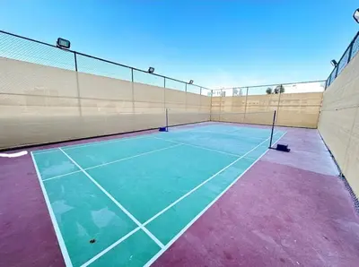 a tennis court with a net on top of it at Fully Equipped Home near Miracle & Butterfly Gardens in Dubai