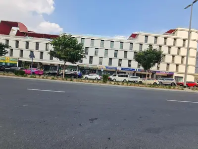 a large white building with cars parked in front of it at Fully Equipped Home near Miracle & Butterfly Gardens in Dubai
