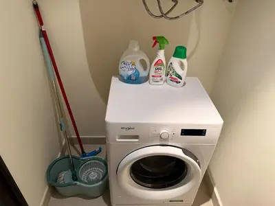 a washing machine with two bottles on top of it at Burj Khalifa 1BR Pool Gym Sauna Dubai Mall in Dubai