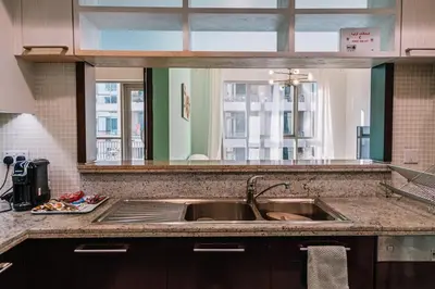 a kitchen counter with a sink and a mirror at Burj Khalifa 1BR Pool Gym Sauna Dubai Mall in Dubai