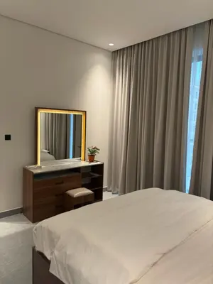 a bedroom with a bed and a dresser with a mirror at Modern Downtown 1BR Apartment in jumeirah Garden in Dubai