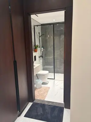 a bathroom with a toilet and a glass door at Modern Downtown 1BR Apartment in jumeirah Garden in Dubai