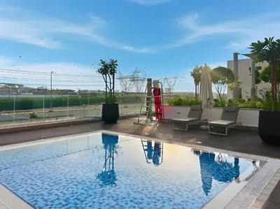 a swimming pool with a view of a building at Chic Studio in Azizi Riviera Minutes to Downtown in Dubai