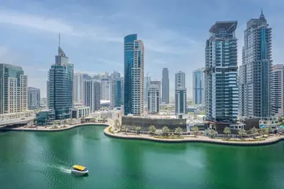 a boat in the water in front of a city at GuestReady - 1BR I Marina Walk - Canal View in Dubai