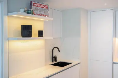 a kitchen with white cabinets and a sink at GuestReady - 1BR I Marina Walk - Canal View in Dubai