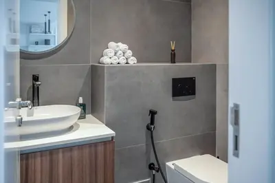 a bathroom with a sink and a toilet and a mirror at GuestReady - 1BR I Marina Walk - Canal View in Dubai