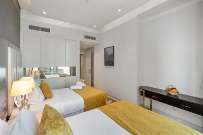a hotel room with two beds and a desk at Nice 2 Bedroom DAMAC Uppercrest Downtown Near Dubai Mall - Partial Burj Khalifa View in Dubai