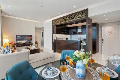 a living room with a couch and a table and chairs at Nice 2 Bedroom DAMAC Uppercrest Downtown Near Dubai Mall - Partial Burj Khalifa View in Dubai