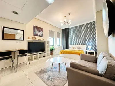 a living room with a couch and a bed at Modern Studio in Executive Bay Business Bay Pool, Gym with WiFi in Dubai