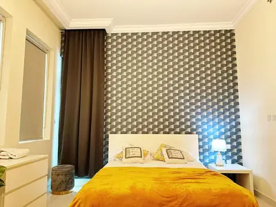 a bedroom with a bed with a checkered wall at Modern Studio in Executive Bay Business Bay Pool, Gym with WiFi in Dubai