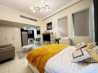 a bedroom with a large bed and a living room at Modern Studio in Executive Bay Business Bay Pool, Gym with WiFi in Dubai