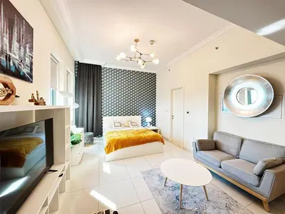 a bedroom with a bed and a couch and a table at Modern Studio in Executive Bay Business Bay Pool, Gym with WiFi in Dubai