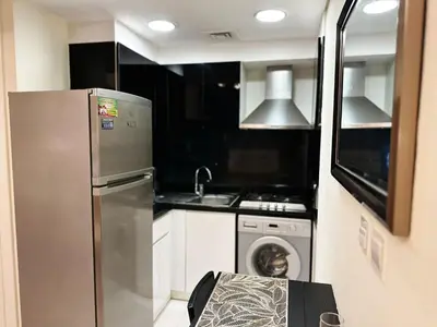 a kitchen with a stainless steel refrigerator and a dishwasher at Modern Studio in Executive Bay Business Bay Pool, Gym with WiFi in Dubai