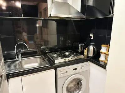 a kitchen with a sink and a stove and a washing machine at Modern Studio in Executive Bay Business Bay Pool, Gym with WiFi in Dubai