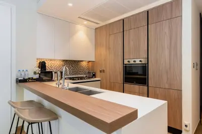 a kitchen with wooden cabinets and a counter top at CitiHome Elegant 1BR Jumeirah Living Dubai Marina in Dubai