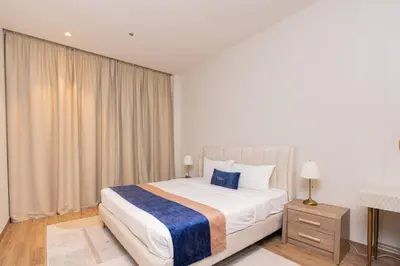 a bedroom with a large bed with white sheets and blue accents at CitiHome Elegant 1BR Jumeirah Living Dubai Marina in Dubai