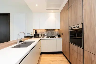 a kitchen with white cabinets and a sink at CitiHome Elegant 1BR Jumeirah Living Dubai Marina in Dubai