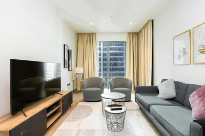 a living room with a couch and a tv at CitiHome Refined 1BR Jumeirah Living Marina Gate in Dubai