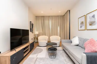 a living room with a couch and a tv at CitiHome Refined 1BR Jumeirah Living Marina Gate in Dubai