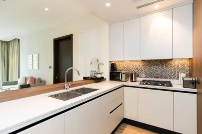 a white kitchen with white cabinets and a sink at CitiHome Refined 1BR Jumeirah Living Marina Gate in Dubai