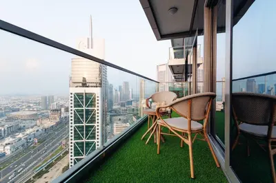 a balcony with two chairs and a table on top of a building at Top Amenities, Luxury 2BR, 5 min. to Burj Khalifa in Dubai